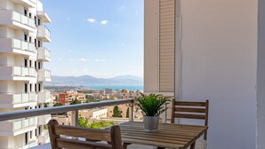 A balcony with a wooden table, two chairs, and a potted plant. - Studio Apartment 'Torremolinos Dream Sea Views' with Sea View, Wi-Fi & Air Conditioning. (Torremolinos)
