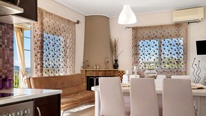 Una cocina moderna con comedor, chimenea y vistas al exterior.