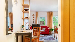 A dining area with a table, chairs, and a red sofa. - Apartment 'Latemar' with Mountain View, Shared Garden and Wi-Fi (Nova Ponente)