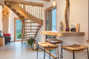 A modern interior with a wooden staircase, a large window, and a wooden bar area. - Chalet 'Himmel' with Mountain View, Private Garden and Wi-Fi (Nova Ponente)