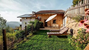 A house with a patio, a dining area, and a view of the mountains. - Chalet 'Himmel' with Mountain View, Private Garden and Wi-Fi (Nova Ponente)