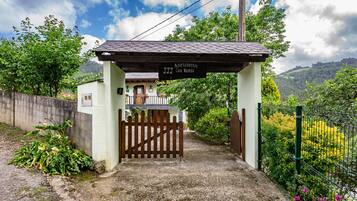 Une entrée fermée par un portail mène à un immeuble sur lequel est apposée une enseigne indiquant « Apartamentos Casa Maseda ».