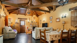 A cozy interior with a dining area, sofas, and a fireplace. - Holiday Home 'Maseda 2' with Mountain Views, Shared Terrace & Private Garden (Villayon)