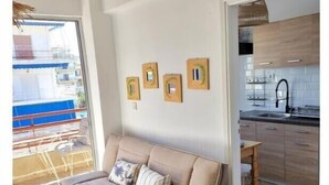 Un salon moderne comprenant un canapé, un coin repas et une cuisine.