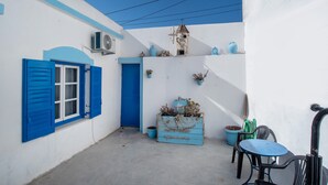 A narrow courtyard with a blue door, a small table, and chairs. - Holiday Home 'Naxos Family House In Vivlos' with Sea View, Wi-Fi and Air Conditioning (Naxos)