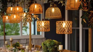 A dining area with long wooden tables set for a meal, surrounded by wicker lamps and greenery. - Isca House, Exeter, NSW, Isca House, Exeter (Exeter)