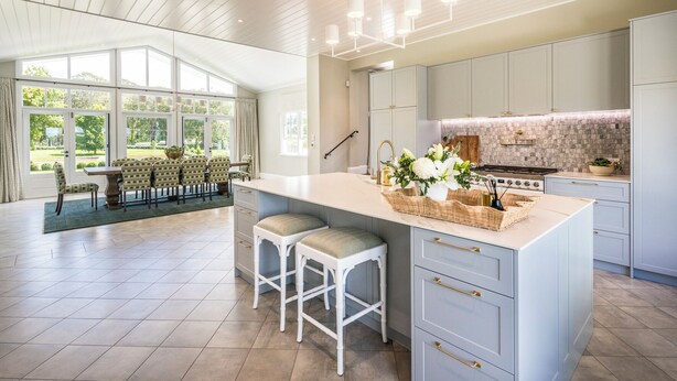 A modern kitchen with a large island, white cabinetry, and a dining area with a table and chairs. - Isca House, Exeter, NSW, Isca House, Exeter (Exeter)