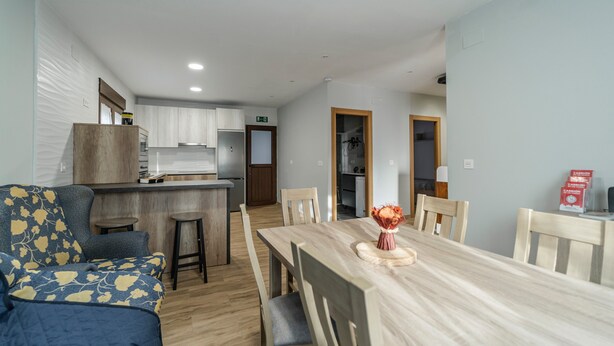 Un espacio habitable compacto con kitchenette, comedor y sofá.