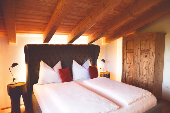 Une chambre à coucher avec un grand lit, une tête de lit en bois et une armoire.