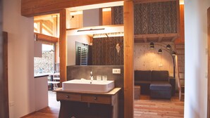 Ein Holzinterieur mit Waschbecken, Spiegel und einer Couch.