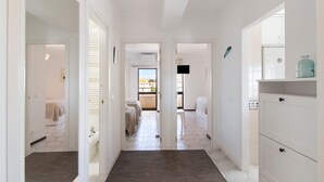 A hotel corridor with a wooden floor, white walls, and a view of a balcony with a bed. - Casa Solimmo' with Sea View, Wi-Fi and Air Conditioning (Quarteira)