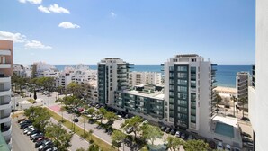A modern high-rise building with a view of the sea, parking, and surrounding urban area. - Casa Solimmo' with Sea View, Wi-Fi and Air Conditioning (Quarteira)