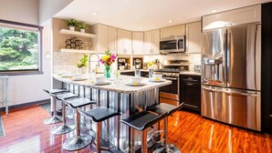 A modern kitchen with a central island, stainless steel appliances, and a view of the outdoors. - Remodeled with Community Amenities in the Canyons Village (Park City)