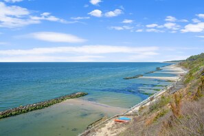 A coastal view with a sandy beach, a wooden walkway, and a clear blue sky. - Sunset on the Rocks | 4BR Bayview Butler's Bluff Retreat w/ Game Room + Pet Friendly (Cape Charles)