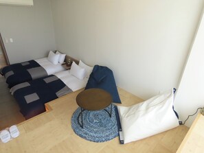 Cozy retreat with a single bed, round table, and woven rug.