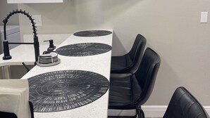 Una cocina moderna con un televisor de pantalla plana montado en la pared que muestra la serie 'Desperate Lies'.