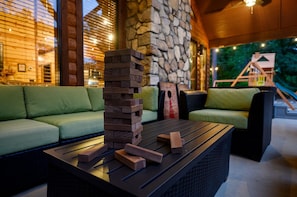 A wooden block tower on a table, green sofas, and a stone wall.
