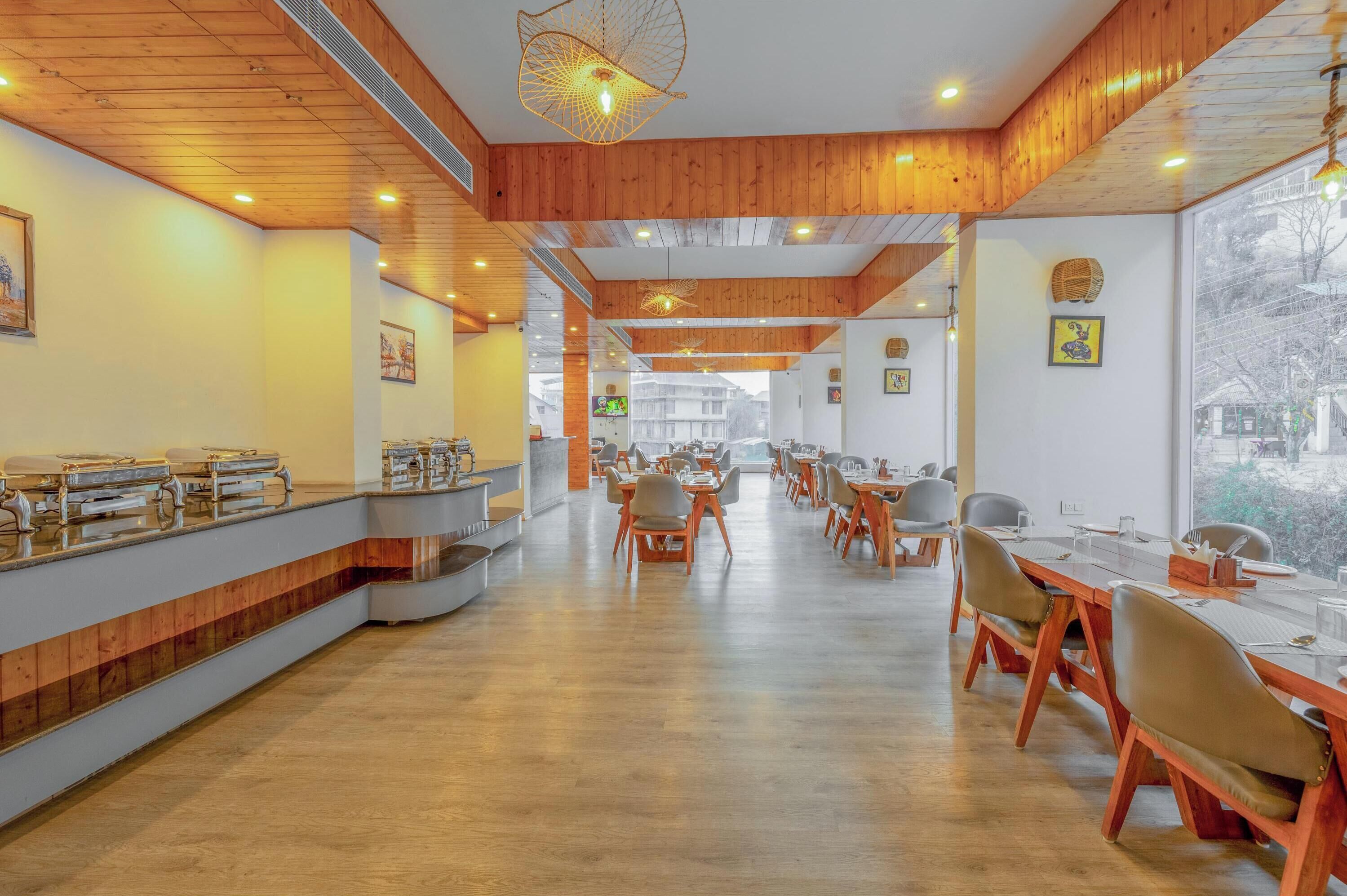 A spacious dining area with wooden paneling, long tables, and chairs.
