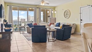 Un salon spacieux avec un grand canapé, une table basse et un ventilateur de plafond.
