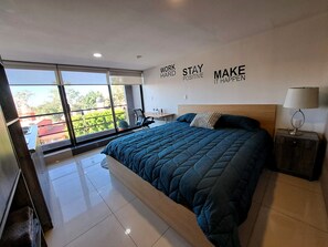 A modern bedroom with a large bed, a nightstand, a desk, and a view through large windows. - S10 PREMIUM SUITE Full Service WiFi (Atizapan de Zaragoza)
