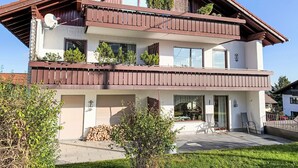 A two-story building with balconies, a garage, and a small garden area. - Auszeit by Interhome (Oy-Mittelberg)
