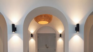 A hallway with white walls, a central door, and two wall-mounted lights. - Villa Poojakanda (Koggala)
