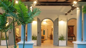 A spacious atrium with high ceilings, multiple archways, and a central open area leading to a seating area. - Villa Poojakanda (Koggala)