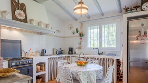 Une cuisine équipée d’une cuisinière, d’un évier, d’un réfrigérateur et d’une table à manger avec des chaises.