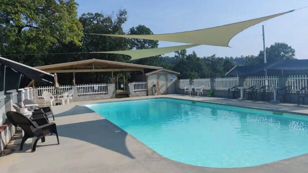 A swimming pool with lounge chairs and a shaded area. - Norfork Lake - Quaint 2 bedroom, no stairs. By the pool -camp store - pavilion. (Elizabeth)