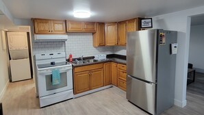 Una cocina moderna con armarios de madera, un refrigerador de acero inoxidable y un horno empotrado.