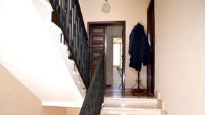 A staircase with a handrail and a door at the top leading to another room. - Kitai Air-conditioned Studio Holiday Home in San Foca (Melendugno)