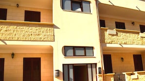A multi-story building with balconies, windows, and a stone facade. - Kitai Air-conditioned Studio Holiday Home in San Foca (Melendugno)