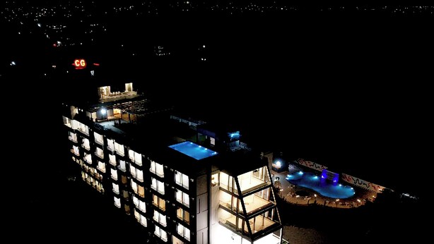 A multi-story hotel with a pool area, featuring a modern architectural design with glass balconies and a rooftop pool. - Hotel The City Crown-Bilaspur (Bilaspur)