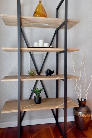 Een meerlaagse houten plankenwand met metalen beugels, waarop verschillende decoratieve voorwerpen staan.