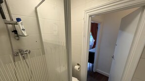 A bathroom with a glass shower enclosure, a toilet, and a bidet. - Studio Apartment Sleeps 2 with Ensuite (London)