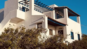 A modern white building with blue accents, a balcony, and a clear blue sky. - Blue orison house Tinos for 5 persons with seaview (Tinos Regional Unit)