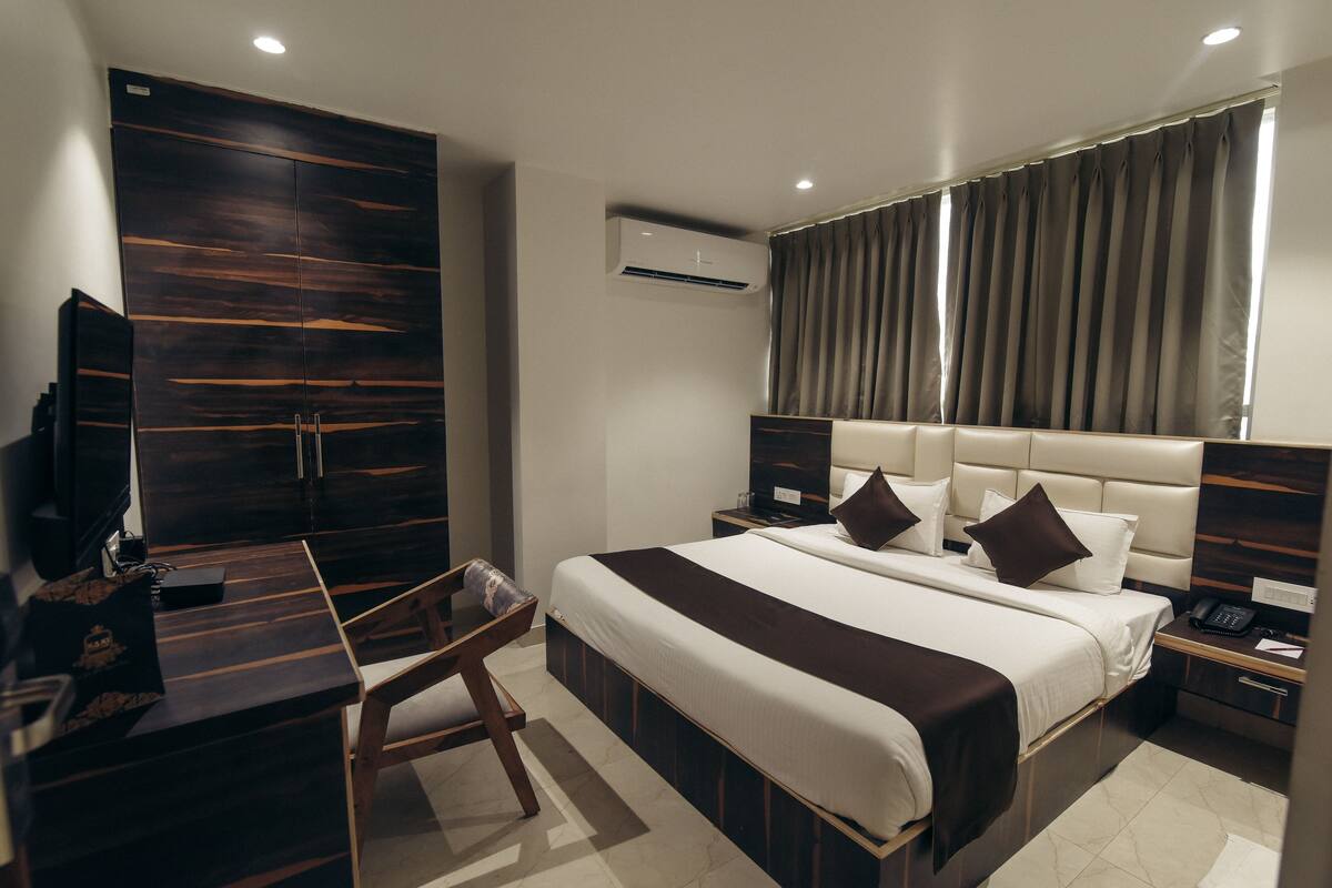 Une chambre d’hôtel moderne équipée d’un grand lit, d’un bureau, d’une chaise et d’une armoire.
