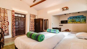 Una habitación de hotel con una cama grande, un armario, un escritorio y un cuadro en la pared.