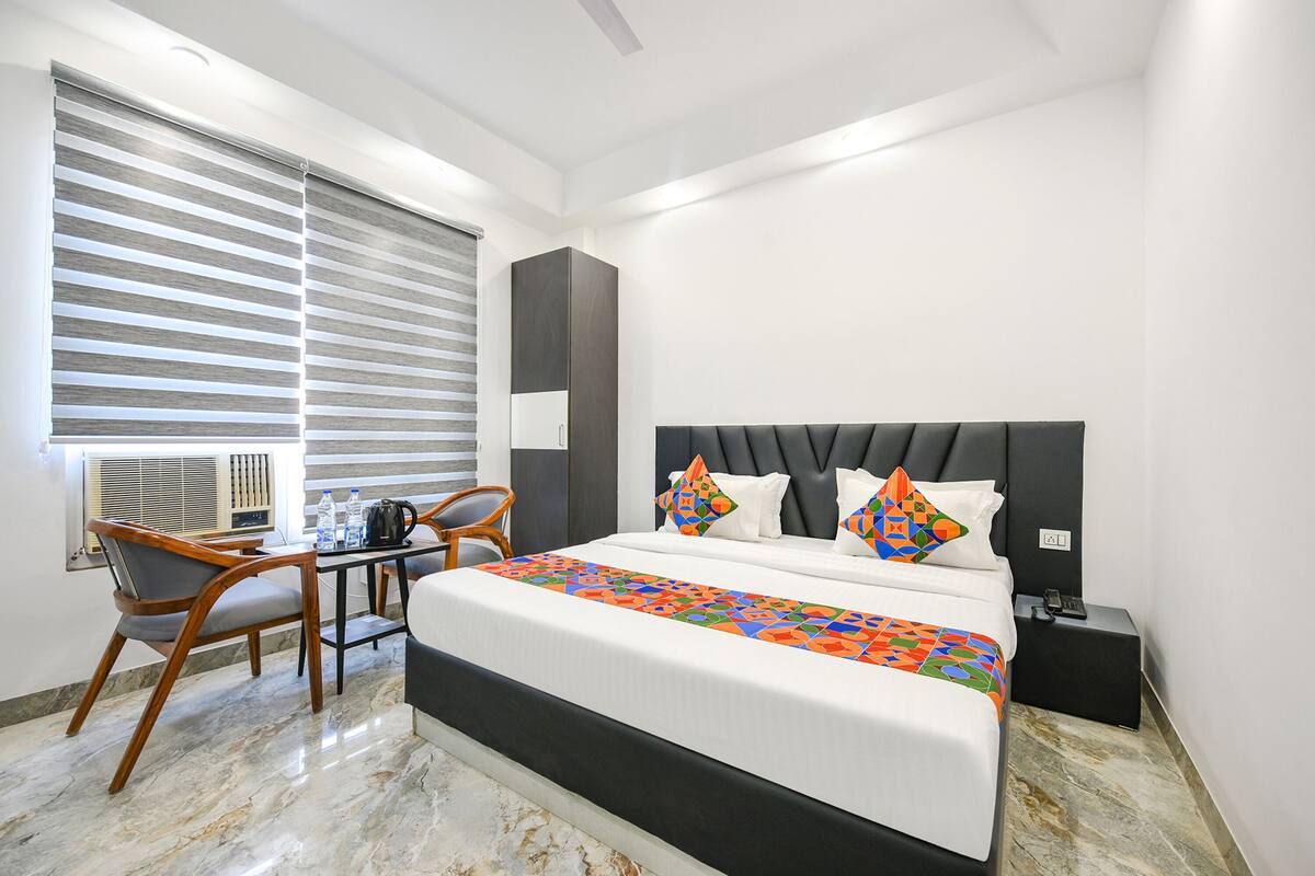 Ein modernes Hotelzimmer mit einem großen Bett, einem Schreibtisch und einem Stuhl.