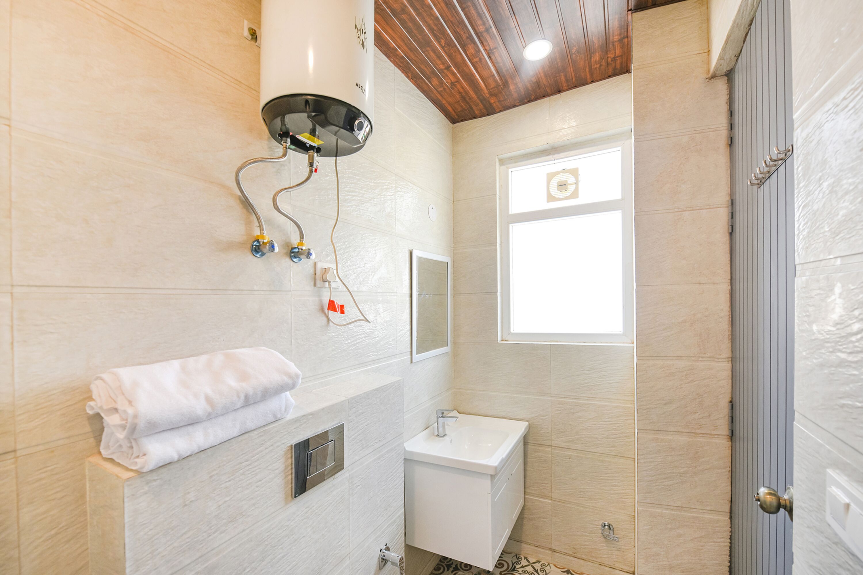 A bathroom with a white sink, a towel rack, and a window.