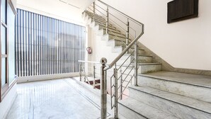 A staircase with metal railings leading to a landing. - Fabhotel K9 Stay (Ludhiana)
