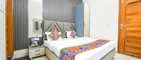 A neatly arranged bedroom with a bed, bedside table, and a wardrobe.