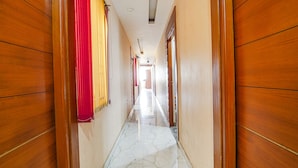 A hallway with wooden walls and a marble floor. - Fabexpress Elegant Residency (Chennai)