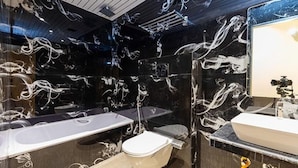 A modern bathroom with a black marble wall, a white sink, and a bathtub. - Fabexpress Green House (Mumbai)