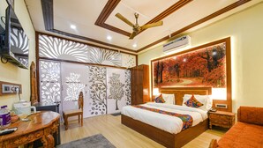 A bedroom with a large bed, a desk, and a chair.