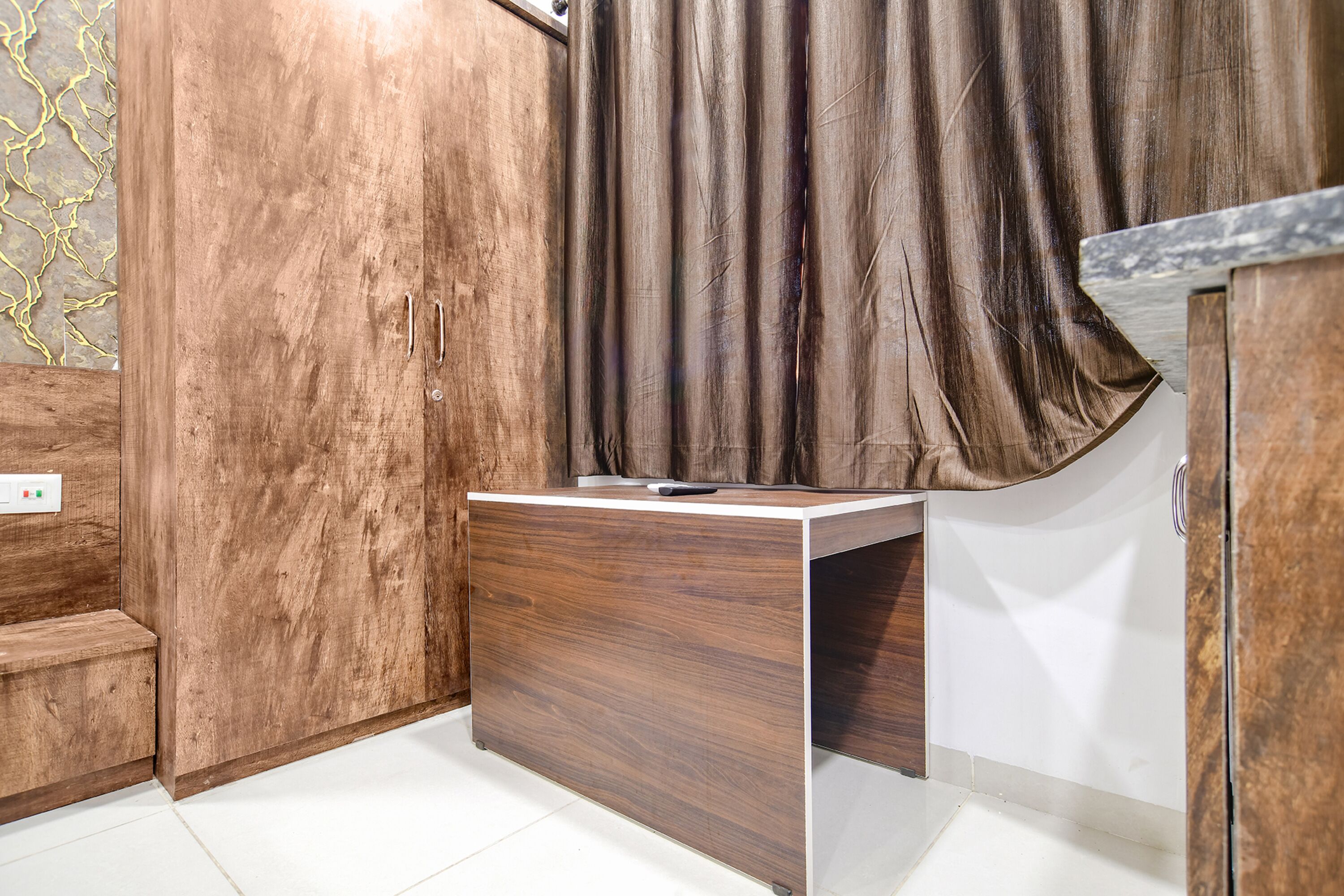 Un bany modern amb un moble de tocador de fusta, un lavabo blanc i una cortina.