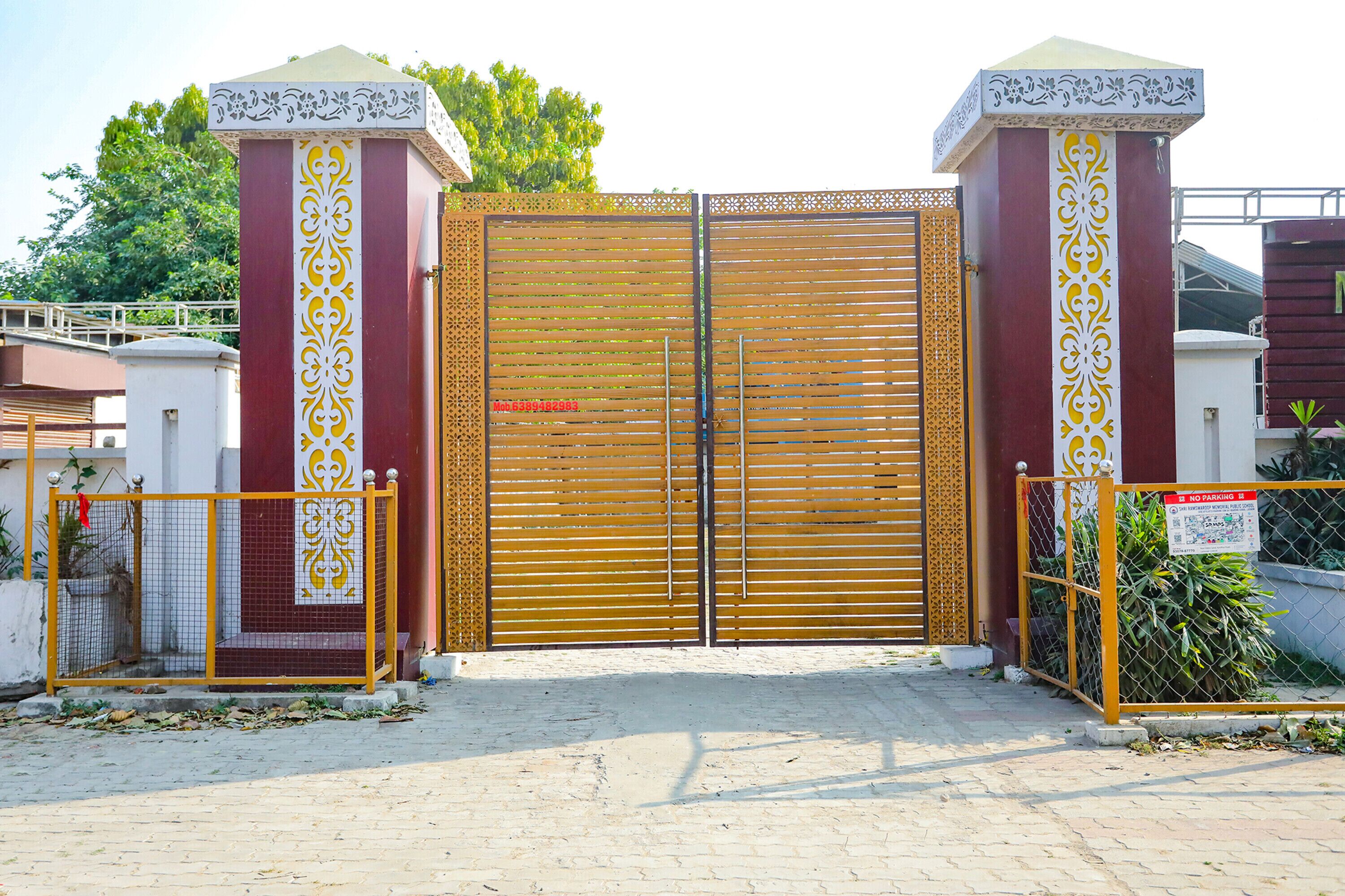 A gated entrance with a decorative metal gate and pillars, a no parking sign, and a paved pathway leading to a building.