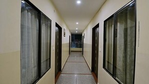 Un corridoio con porte di vetro su entrambi i lati, che conduce a una scala.