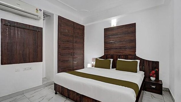 Una camera da letto con un letto grande, una testiera in legno e un comodino con un vaso.