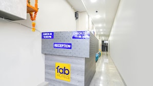 A reception desk with check-in and check-out times, a reception area, and a logo for Fab Hotels.